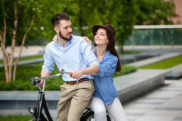 Young couple sitting on a bicycle 