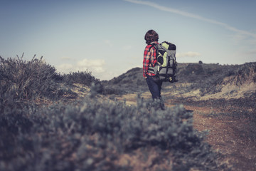 Backpacker walking through hilly scrub
