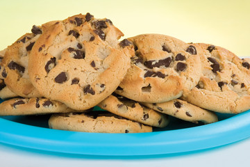 Chocolate Chip Cookies – A blue plate of chocolate chip cookies. Yellow background.