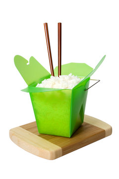 Chinese Takeout – White rice in a green Chinese food takeout container. Chopsticks in the rice. Isolated on a white background.