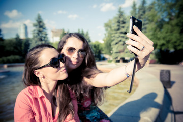 Two young women taking a selfie outdoors