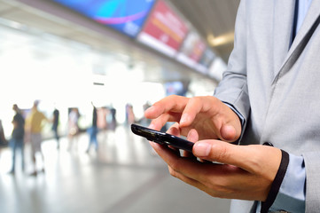 Business Man using Mobile Phone in Modern Train Station