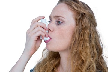 Pretty blonde using an asthma inhaler