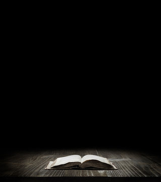 Image of a book on wooden background in a dark space