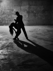 Man and woman dancing, concrete building surroundings - obrazy, fototapety, plakaty
