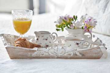 Fototapeta na wymiar Croissant and tea with juice on breakfast tray