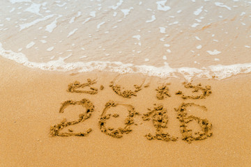 New Year 2016  - inscription 2015 and 2016 on a beach sand. Selective focus.