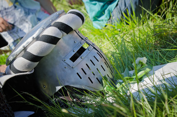 Medieval knight iron helmet lies in the grass