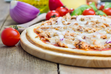 Pizza with tuna fish on a wooden board