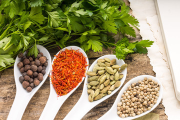 Recipe book background. Diversity of spices with bunch of parsley.