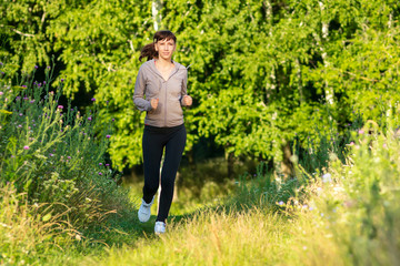 Young woman jogging in summer morning park