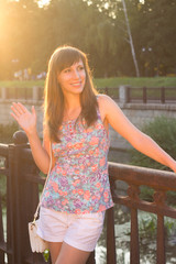Young beautiful hipster woman greeting somebody at the embankment