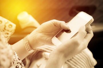 Woman using smartphone in car. Vintage filter
