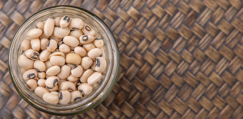 Black eye pea in mason jar over wicker background