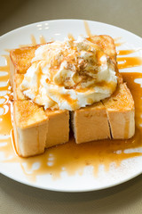 Golden honey toast in the white dish with whipped cream on top