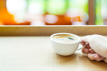 Espresso Coffee cup on wood table in cafe with blur green garden