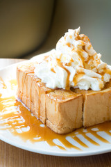 Golden honey toast in the white dish with whipped cream on top