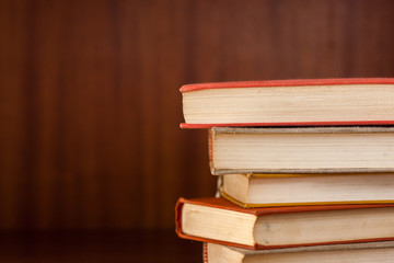 Stack of books sorted in front of wooden background