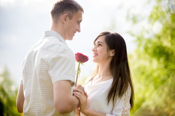 Young man giving flowers to girlfriend