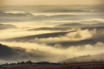 fog through hills on autumn morning