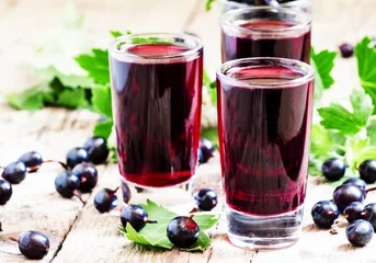 Crédence de cuisine en verre imprimé Jus Fresh black currant juice with berries in glasses on an old wood