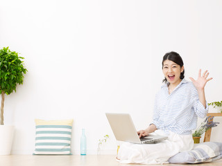 部屋でパソコンを使う女性　驚く