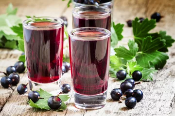 Door stickers Juice Fresh black currant juice with berries in glasses on an old wood