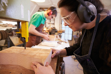 Shoemakers cutting and shaping wood to make shoe lasts