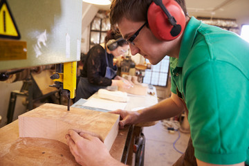 Shoemakers cutting and shaping wood to make shoe lasts