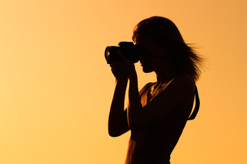 Silhouette of a woman photographing