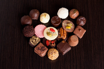 Delicious chocolate candies on wooden background