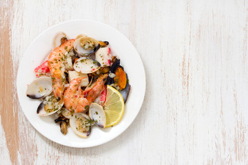 seafood salad on plate on white wooden background