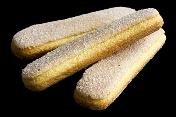 Savoiardi italian sponge biscuits isolated on black.