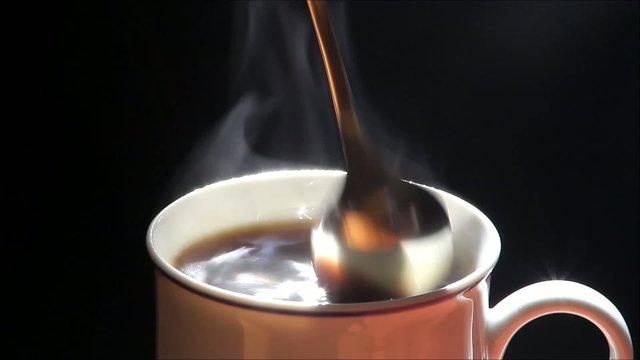 heisser kaffee in kaffeetasse mit loffel umr&uuml;hren   

 
