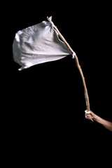 Hand holding white flag against black background