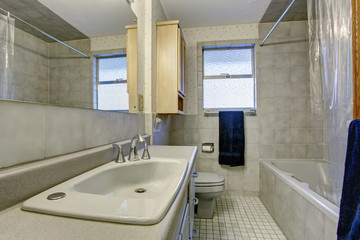 Naklejka na ściany i meble Simple bathroom with tile floors and window.