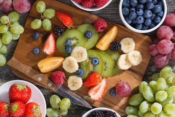 ingredients for fruit salad on wooden board, horizontal