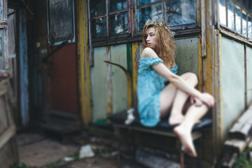 young and beautiful girl sitting at the door