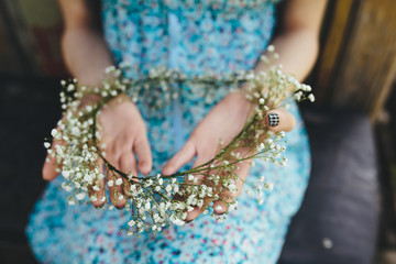 Girl holds head wreath in hands