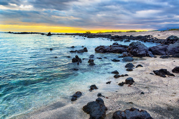 Sunset over a rocky beach on Isabela Island in the Galapagos Islands in Ecuador
