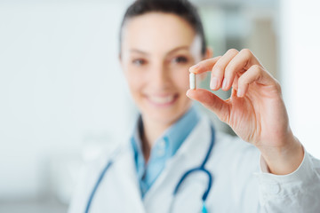 Pharmacist holding a pill - Powered by Adobe