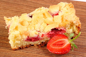 Fresh baked yeast cake with strawberries on wooden table