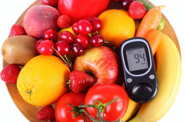 Glucometer with fruits and vegetables on wooden plate