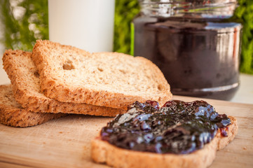 breakfast with sour cherry marmalade on toast with a glass of milk and frutis