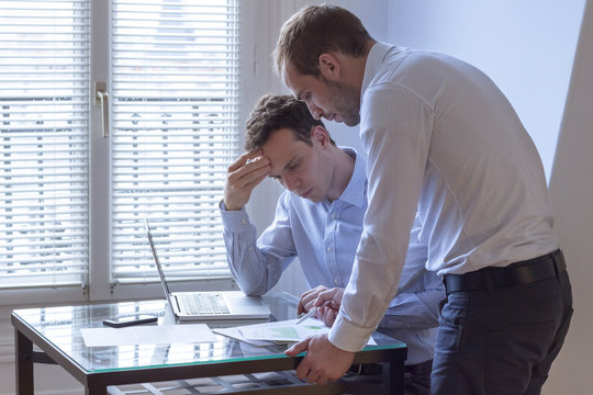 Meeting of two businessmen with laptop and charts