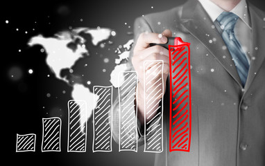 Business man drawing a growing graph
