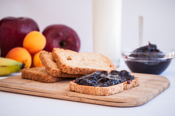 breakfast with sour cherry marmalade on toast with a glass of milk and frutis