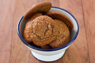 cookies in bowl on brown wooden background