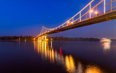 Fototapeta na wymiar Footbridge in the evening Kiev city. Ukraine