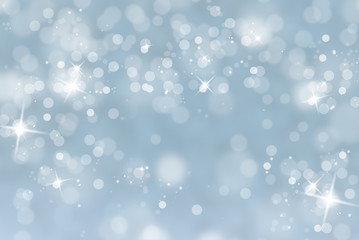 Blurry abstract bokeh lights on light blue background with sparkle. Beautiful snowy holiday greeting card illustration with place for text.